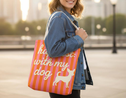 Woman holding a tote bag with a dog design and text in an urban setting