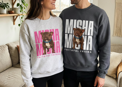 Two people wearing matching sweatshirts with a dog graphic and text in a living room.
